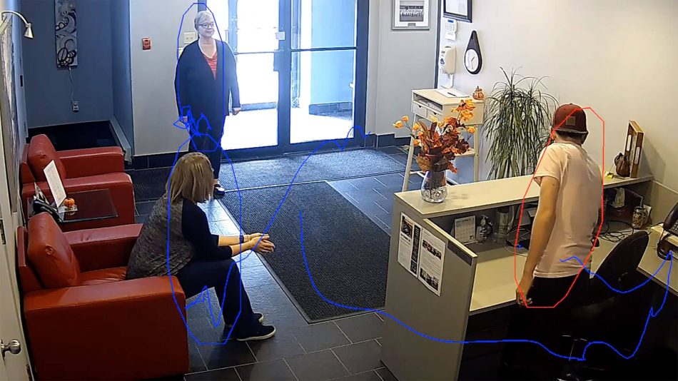 Analytics boxes around three people in the foyer of a work place with analytic lines indicating the movements they made to get to their current positions to show Senstar's Indoor People Tracking video analytic