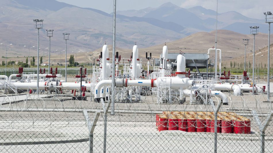 Große Pumpstation mit mehreren Rohren und Ölfässern, die von einem umzäunten Umfang umgeben sind, um die Perimeter-Intrusionserkennungsfähigkeiten von Senstar zu demonstrieren