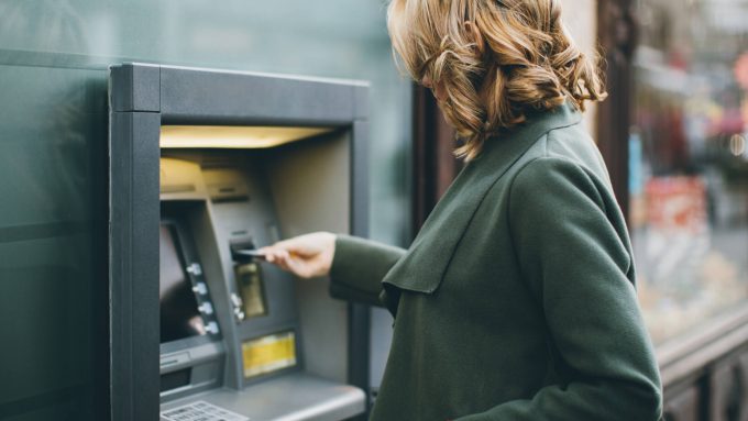 Woman inserting bank card into ATM to demonstrate Senstar's position in the banking industry