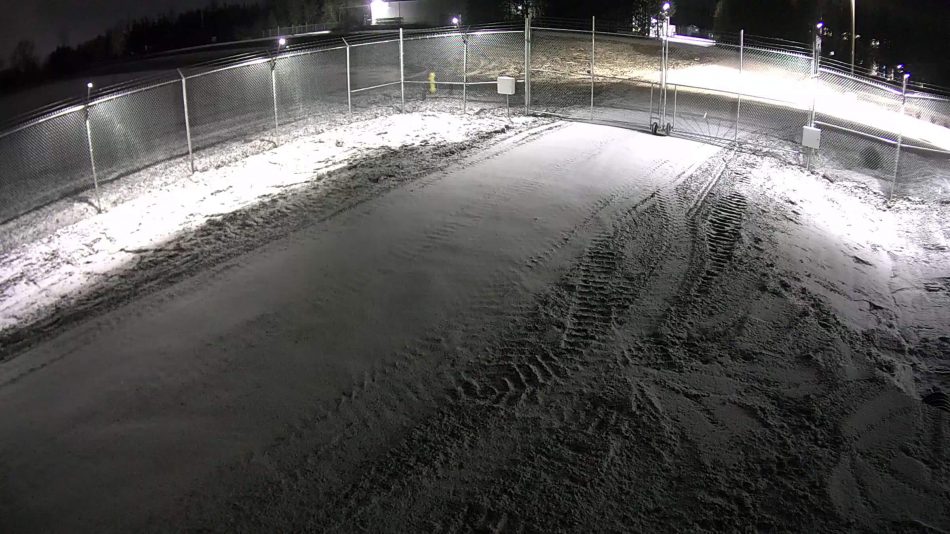 Captura de videovigilancia de Senstar LM100detección híbrida de intrusiones perimetrales y sistema de iluminación inteligente en uso por la noche a lo largo de una valla