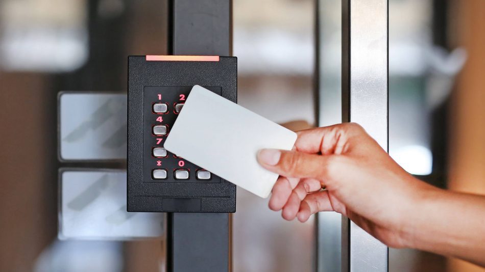 Symphony Access Control software - stock image of a hand holding an access card in front of an access keypad on a door