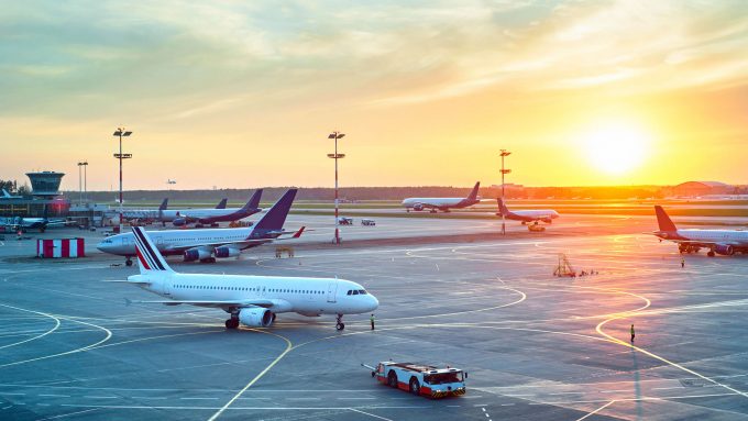 Mehrere Flugzeuge auf dem Rollfeld eines Flughafens bei Sonnenuntergang demonstrieren die Fähigkeit von Senstar, Flughäfen vor Einbrüchen zu schützen und die Videoüberwachung zu verwalten und zu analysieren